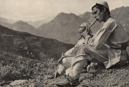 Twee mannen in de bergen spelen op een fluit