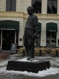 Standbeeld van Albert Schweitzer op een lage sokkel met resten sneeuw