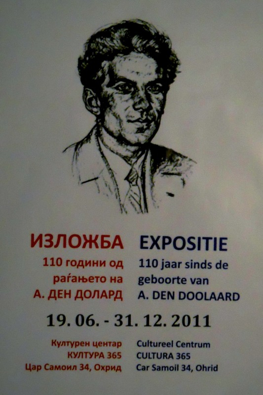 Poster met portret van een jeugdige A. den Doolaard en gegevens over de expositie in het Macedonisch en het Nederlands.